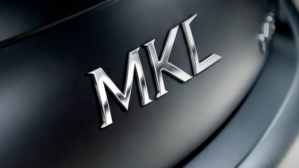 Emblema cromado MKL sobre portón negro mate